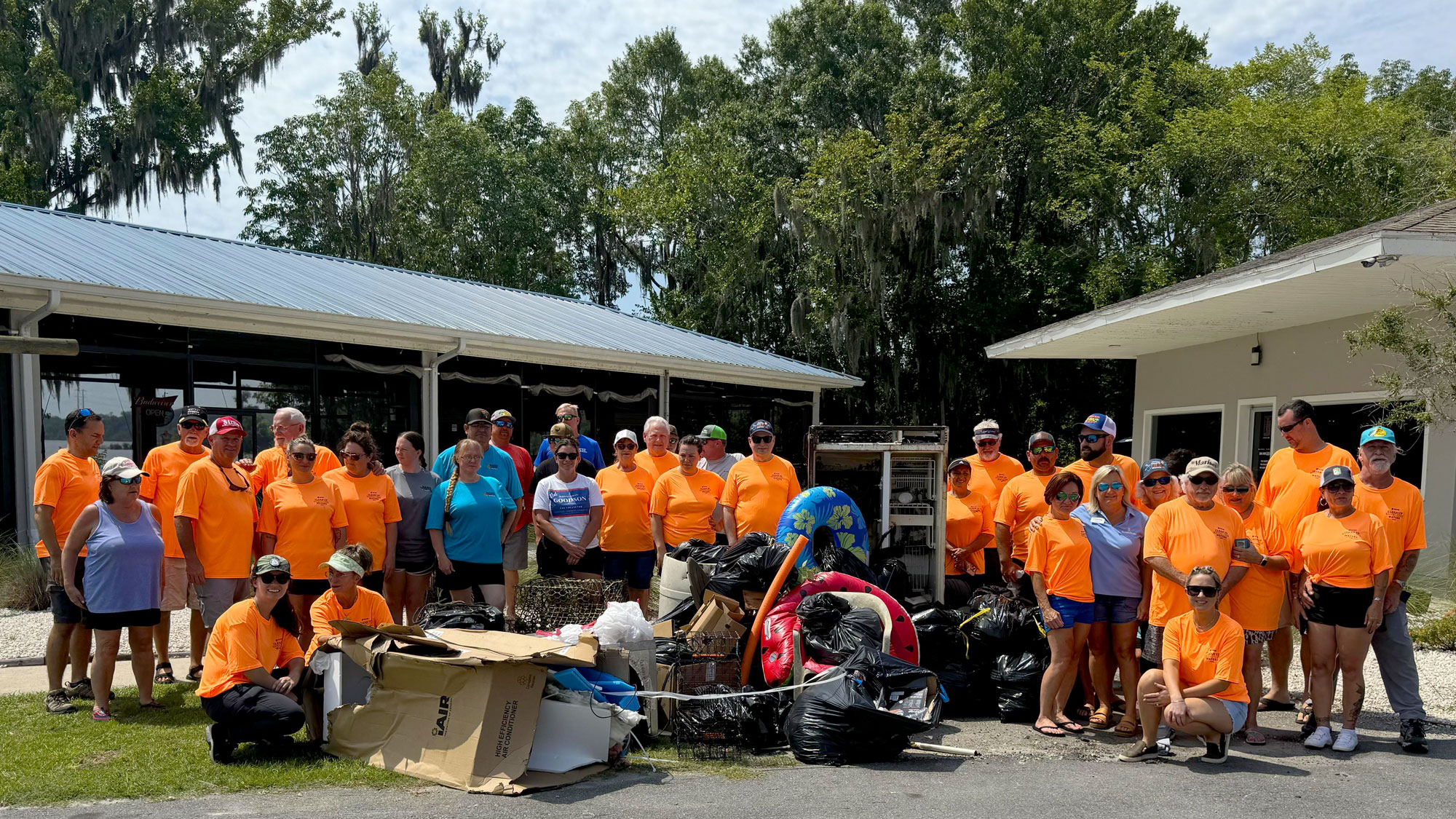 Group of volunteers standing next to the 1,000 lbs of trash they collected in Putnam County.