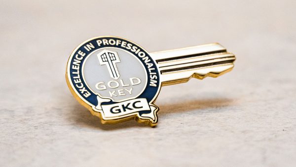Gold Key Certification pin sitting on a table